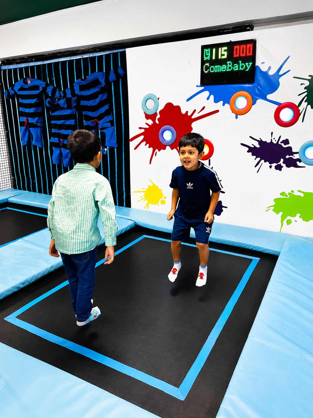 Kids bouncing in the trampoline zone with splatter wall and scoreboard
